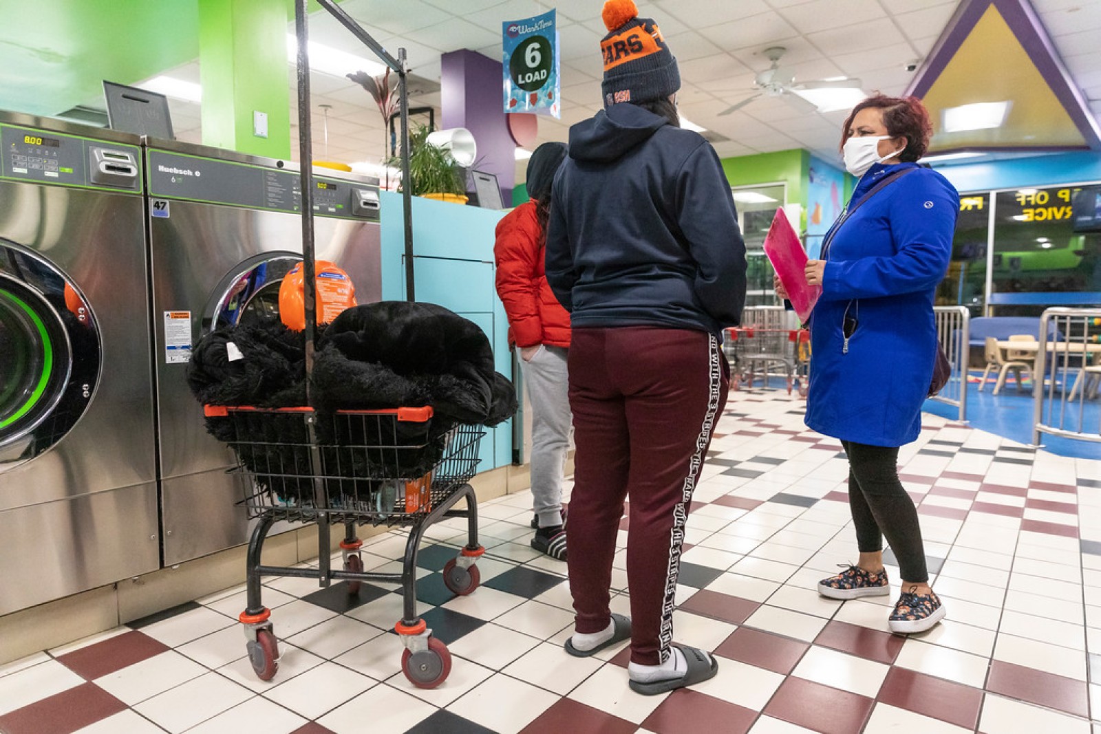 Margarita Sanchez, a promotora de salud — community health worker — with Centro San Bonifacia, conducts a survey about COVID-19 and helps answer questions for people on Jan. 15, 2021, at a laundromat in Belmont Cragin on Chicago's Northwest Side. Manuel Martinez / WBEZ News. Margarita Sanchez, a promotora de salud — community health worker — with Centro San Bonifacia, conducts a survey about COVID-19 and helps answer questions for people on Jan. 15, 2021, at a laundromat in Belmont Cragin on Chicago's Northwest Side. Manuel Martinez / WBEZ News.