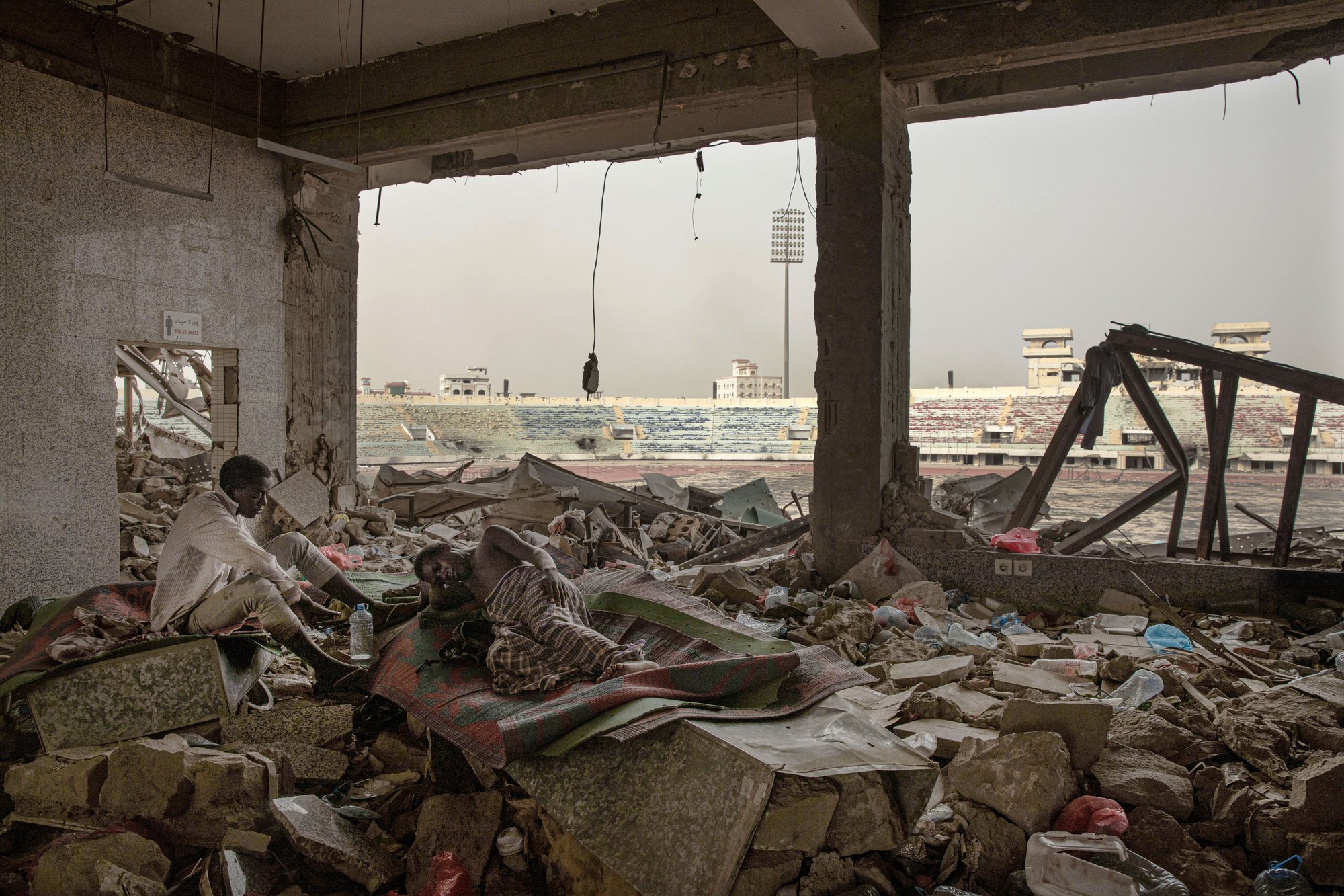 Ethiopian migrants take shelter in the "22nd May Soccer Stadium," destroyed by war, in Aden, Yemen. Image AP Photo/Nariman El-Mofty. Yemen, 2020. Ethiopian migrants take shelter in the "22nd May Soccer Stadium," destroyed by war, in Aden, Yemen. Image AP Photo/Nariman El-Mofty. Yemen, 2020.