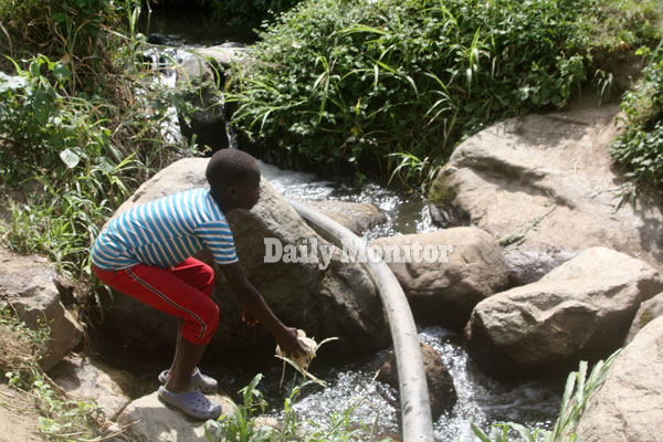A child dumps waste in river Mpanga in Karangura in Kabarole District, Uganda. Image by Felix Basiime. Uganda, undated. A child dumps waste in river Mpanga in Karangura in Kabarole District, Uganda. Image by Felix Basiime. Uganda, undated.