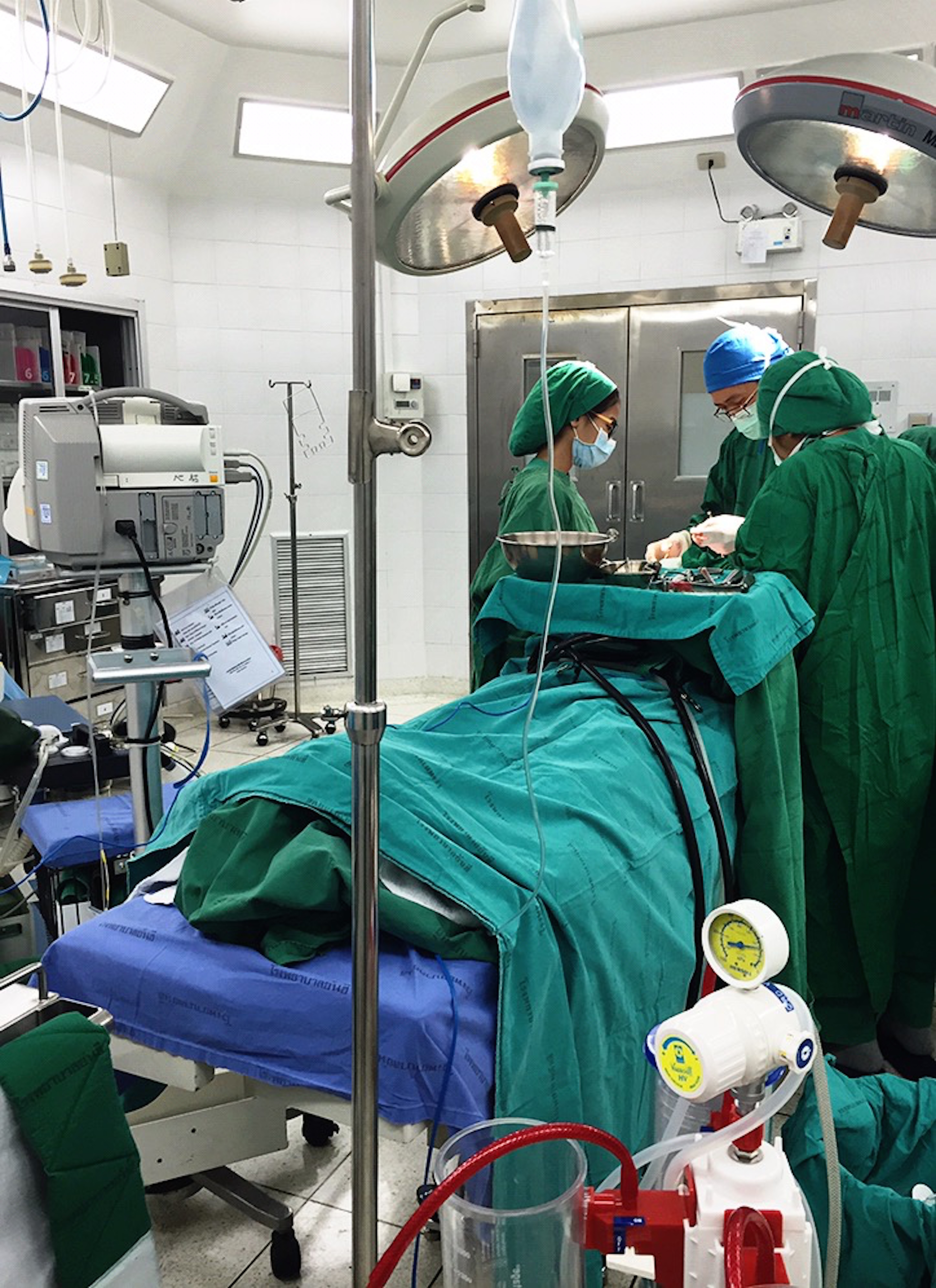 Dr. Greechart (middle) of Yanhee International Hospital performs a two-hour facial feminization surgery on a transgender patient. Image by Julia Boccagno. Thailand, 2015.