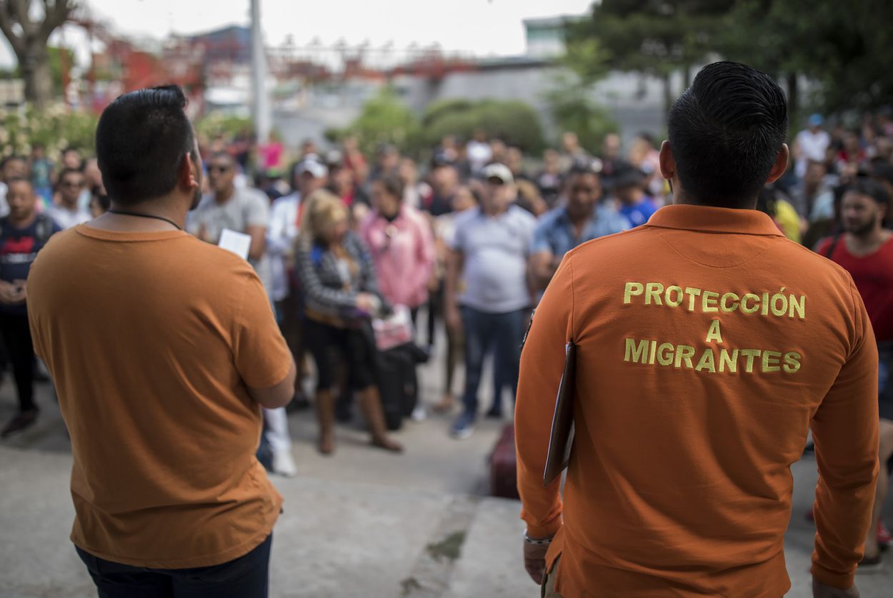 Workers from the Centro de Atención Integral a Migrantes (CAIM) call out numbers from the asylum waiting list outside the center in Ciudad Juárez on May 13, 2019. Image by Ivan Pierre Aguirre. Mexico, 2019. Workers from the Centro de Atención Integral a Migrantes (CAIM) call out numbers from the asylum waiting list outside the center in Ciudad Juárez on May 13, 2019. Image by Ivan Pierre Aguirre. Mexico, 2019.