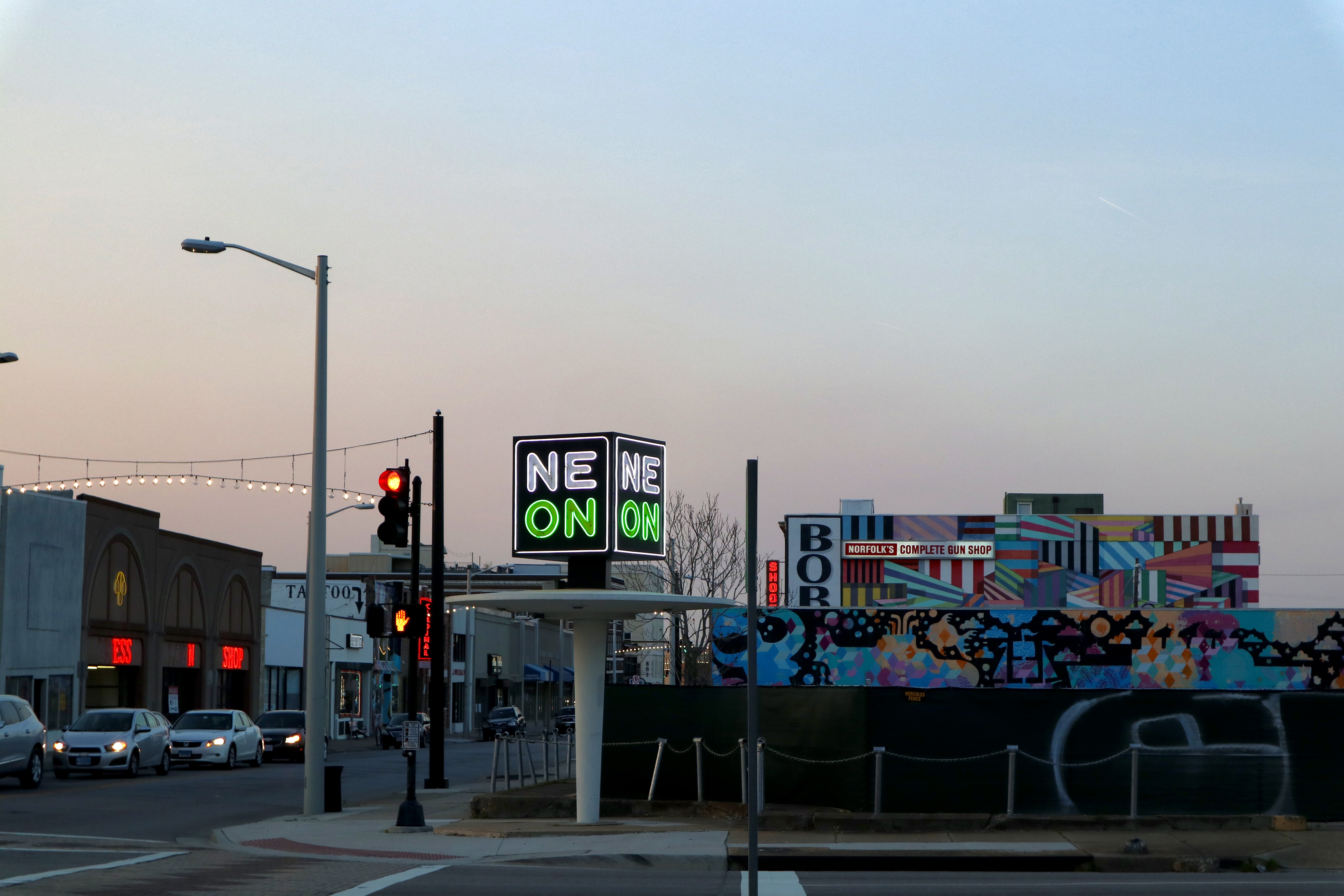 A neon sign reading "NEON" is lit up against the dusk sky.