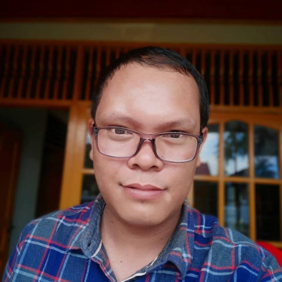 A person wears a blue shirt with glasses.