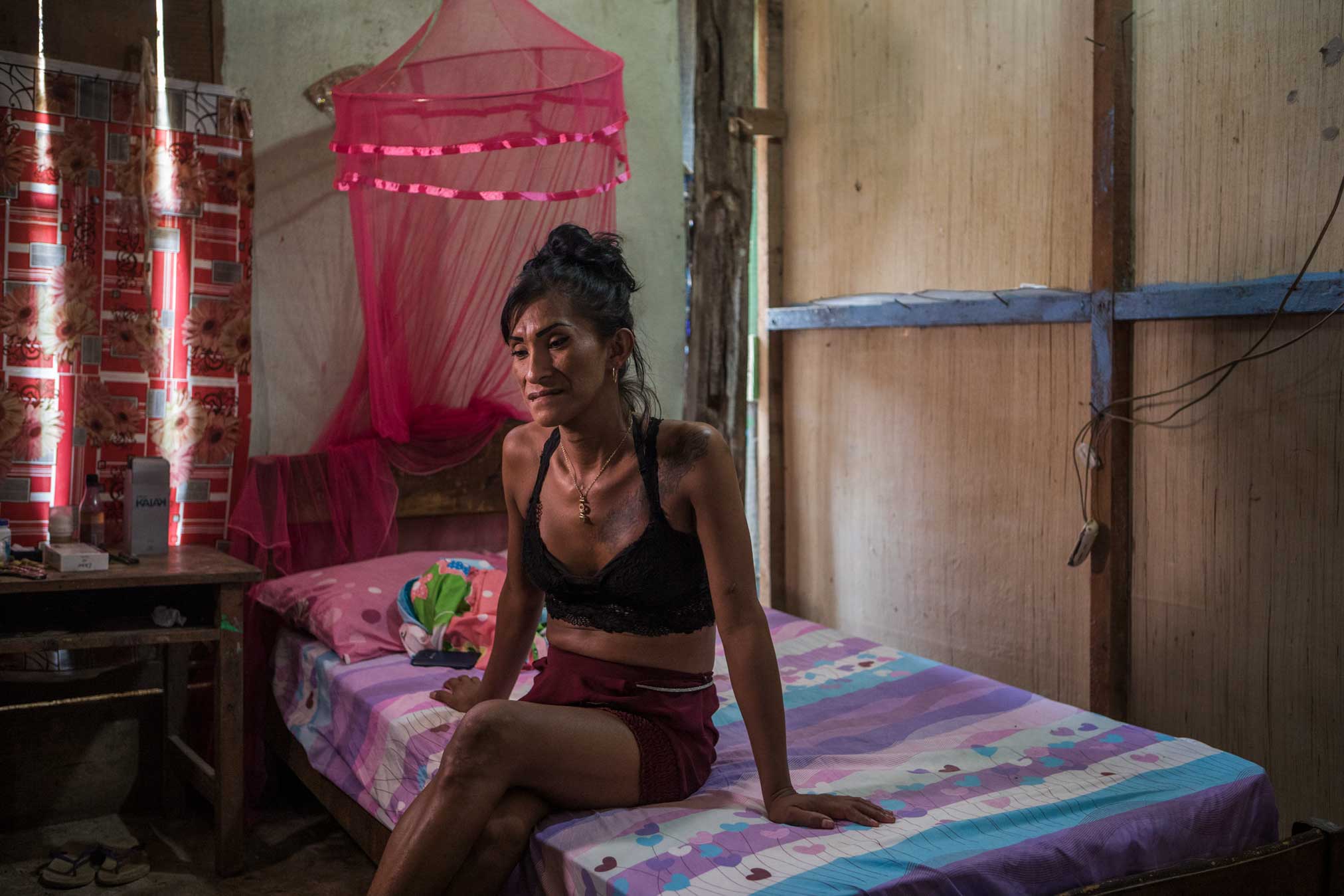 a woman sits on her bed, Peru