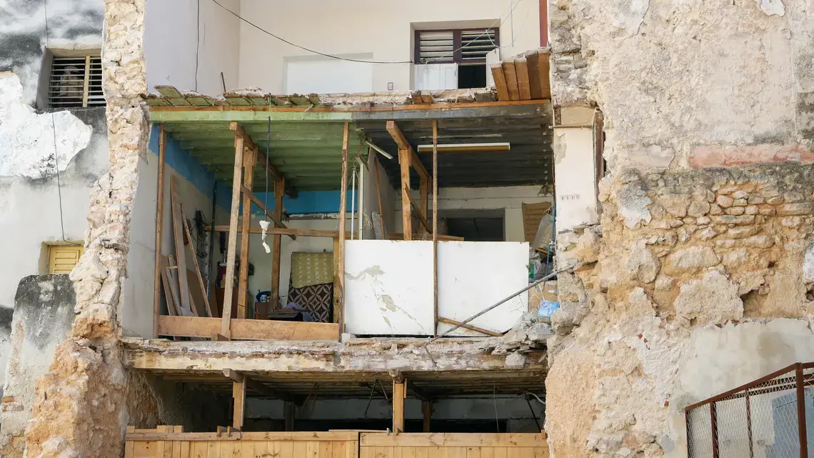 Half the kitchen and bedroom of this home suddenly peeled from the apartment one day. Residents escaped without injury, but lost a stove and other belongings. Image by Tracey Eaton. Cuba, 2018.