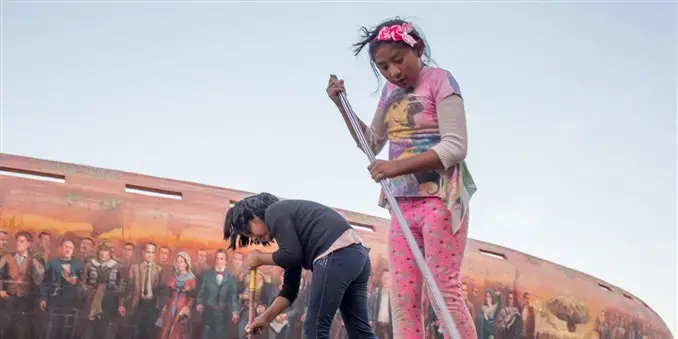 An 8-year-old child, right, and her friend sweep the pavement outside the Jaime Laredo Outdoor Theater in La Paz. Children are allowed to work for themselves or their families at age 10 in Bolivia. At 12, they can work for others. Image by Tracey Eaton. Bolivia, 2018.