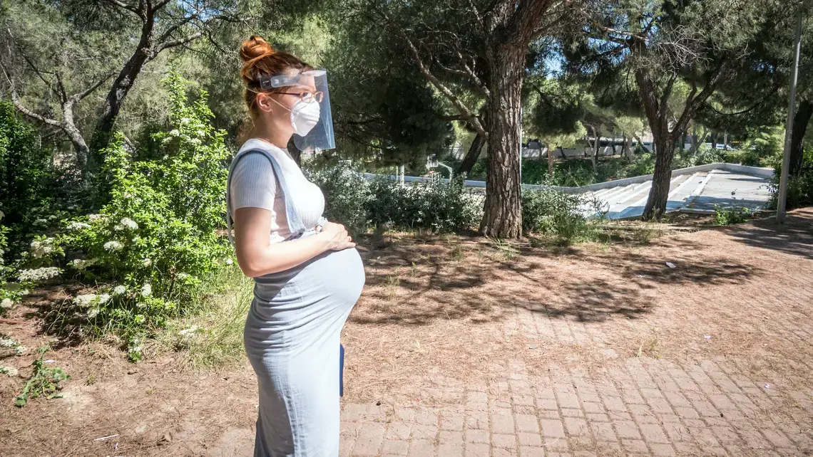 A pregnant woman goes for a walk in a public park in Madrid. Image by JoeLogan / Shutterstock. Spain, 2020.
