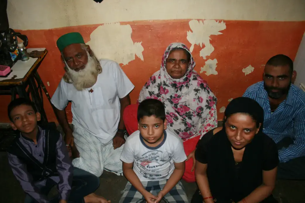 Shamin Ansari, 14 (left) lives with his brother, parents, and grandparents in a one-room flat in Shivaji Nagar. Born with intellectual disabilities, Shamin’s family worked with Apnalaya, a local NGO, to obtain the government-issued disability certificate required for his admission into a special school. Image by Kate Petcosky-Kulkarni. Mumbai, India, 2016.