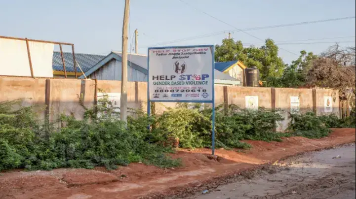 A sign advertising a hotline for people to call and report gender based violence related crimes in Wajir, Kenya. Image by Peter DiCampo. 2018.