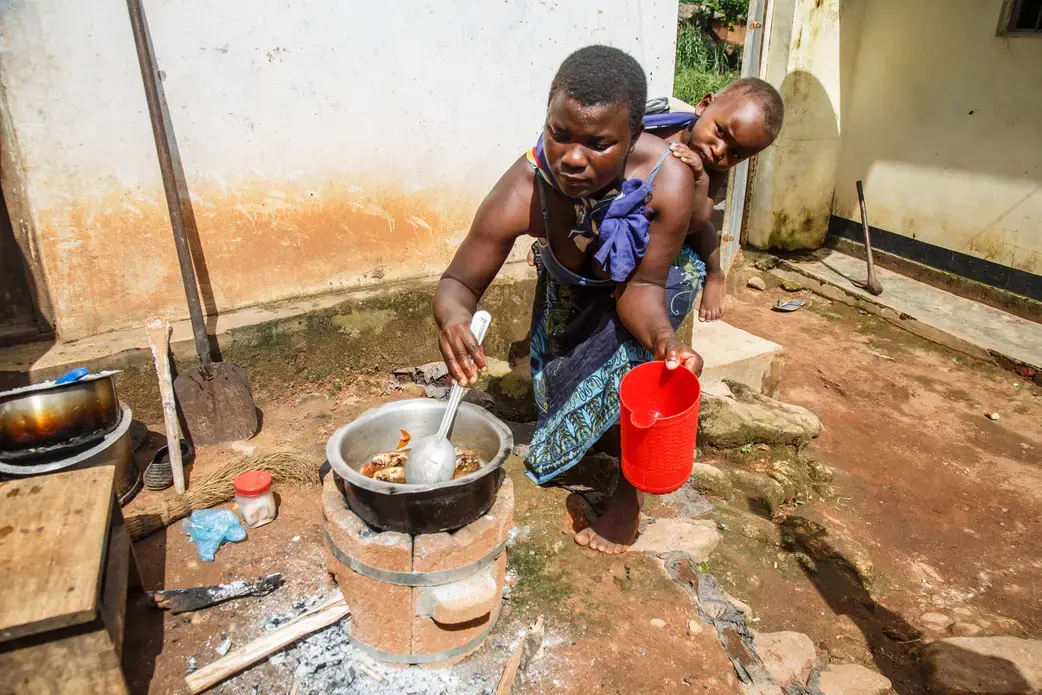 Flora Kandodo of Nessa village near Mulanje, Malawi, is cooking relish on her new Aleva stove—an improved cook stove that is fuel efficient and smokes less. Image by Nathalie Bertrams. Malawi, 2017.