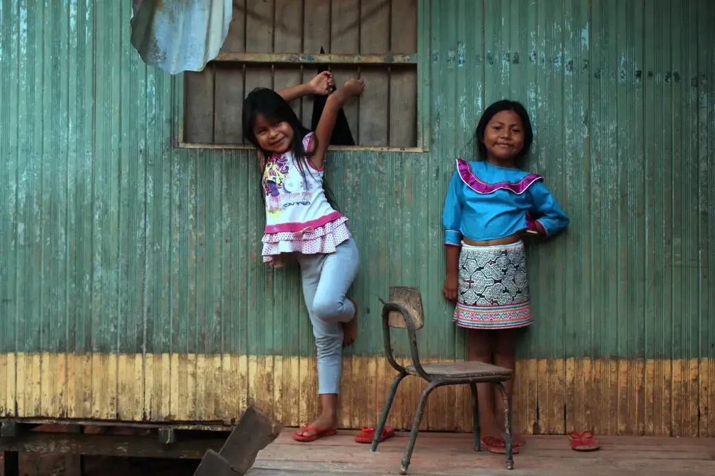 Angi and Sophia, Karina's nieces, pose against a wall of their home in Pucallpa.&nbsp;Image by Natalie Hutchison. Peru, 2017.