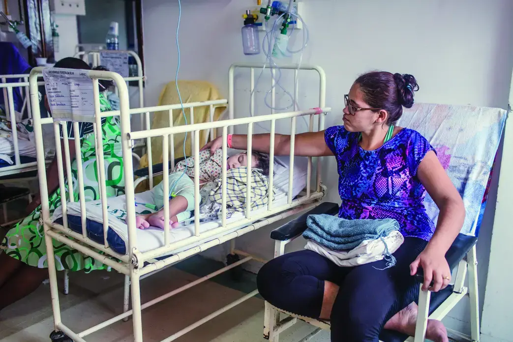 Mylene Helena dos Santos Ferreira e seu filho Davi aguardando para falar com o médico no hospital. Fotografia por Fábio Erdos. Brazil, 2017.