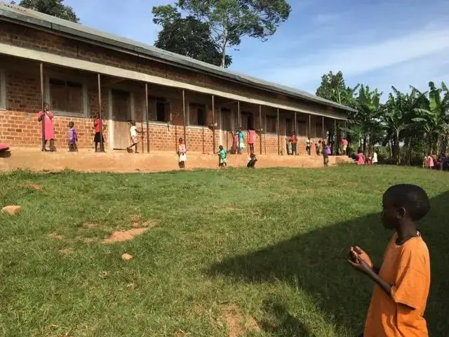 Students play in the school yard of a Building Tomorrow School as they wait to receive their report cards. Image by Brandon Posner. Uganda, 2016.