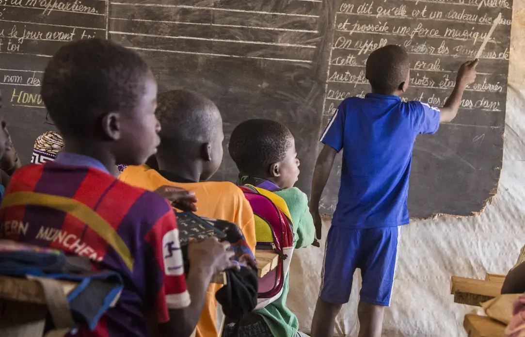 Children learn in a makeshift classroom located in a sprawling camp for thousands of displaced families in the Central African Republic. Image by Jack Losh. Central African Republic, 2018.