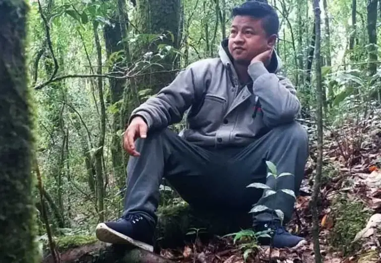 Borhlang Blah, 27, inside a sacred grove—a community forest protected by his village—in Mawphlang, Meghalaya. When Blah was growing up, the grove was denser and walking difficult. The grove and Meghalaya’s forests have thinned out since. Image by Disha Shetty. India, 2019.