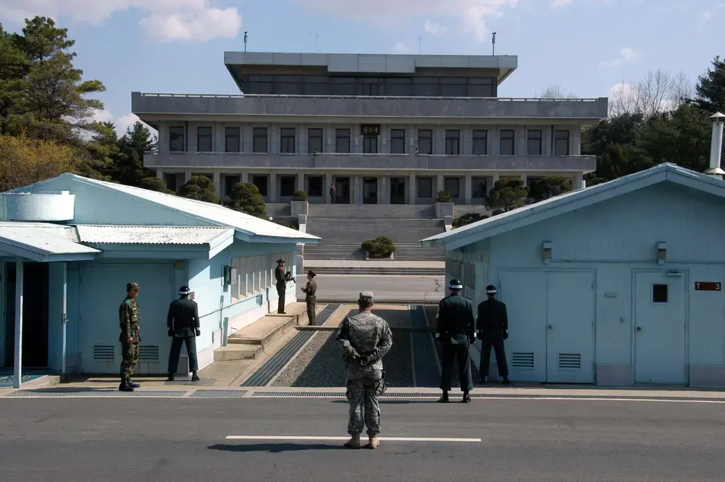 A view from South Korea towards North Korea in the Joint Security Area at Panmunjom. North and South Korean military personnel, as well as a single US soldier, are shown. Image by user: Driedprawns/Wikimedia Commons. South Korea, 2007.
