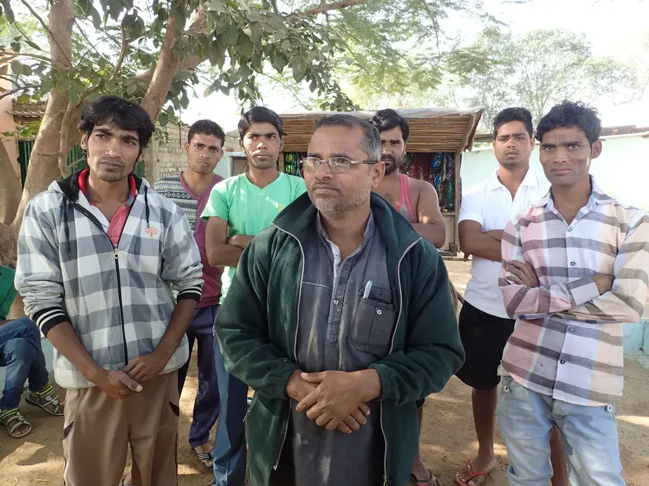 A group of high school and college students standing with a street vendor on the road outside Bade Seepat. Despite their education, they all said they expected to end up migrating to brick kilns like their parents. Image by Yardain Amron. India, 2017.