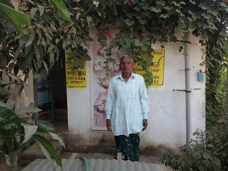 In Pihrid, a villager stands in front of two latrines he was ordered to construct as part of a government sanitation scheme. Each latrine cost Rs 50,000, or about $770. Image by Yardain Amron. India, 2017.