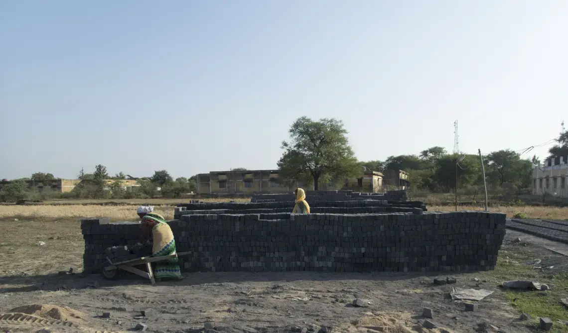 Women working at a small, temporary brick factory in Malda village. While most of the laborers at this factory were local relatives of the owner, the industry is notorious for exploiting migrant labor. Image by Yardain Amron. India, 2016.