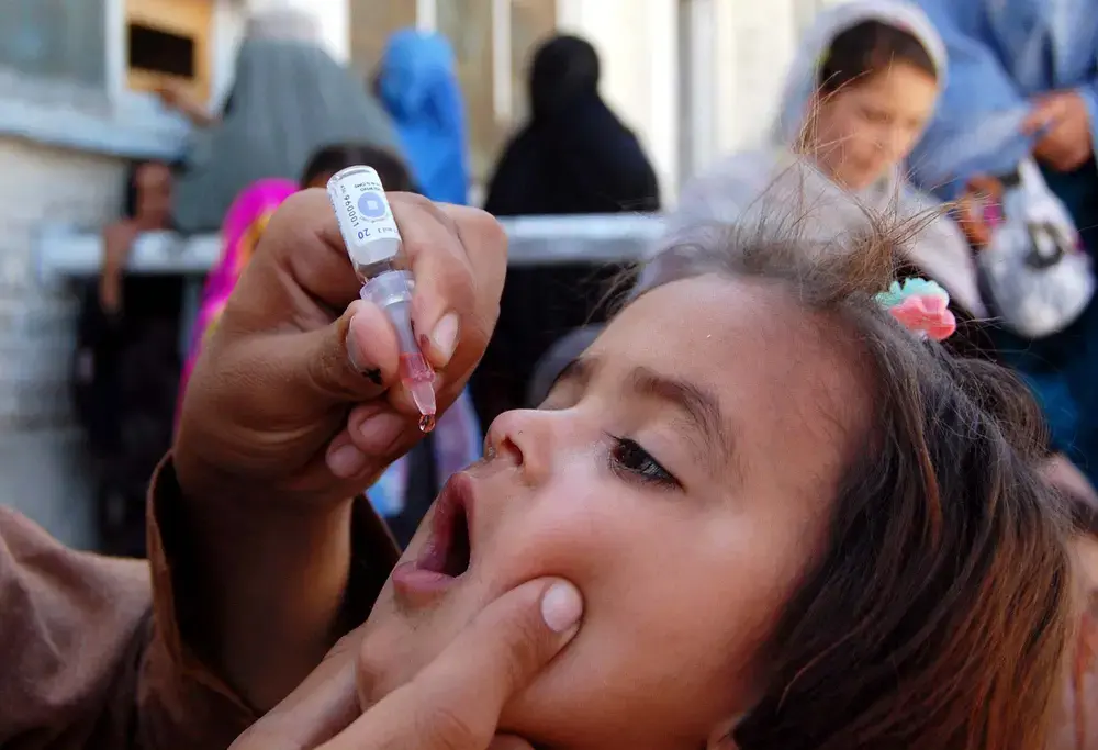 Health worker administrates polio-vaccine drops to a child during anti-polio immunization campaign at Pak-Afghan Border on April 08, 2015 in Chaman. Image by Shutterstock. Pakistan, 2015.