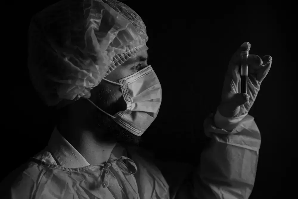 A doctor examines a blood sample. Image by Alena Marchuk / Shutterstock. 2020.