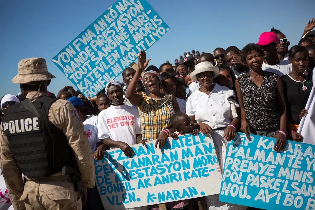 Protesters at a memorial commemorating the five-year anniversary of the 2010 earthquake. Image by Allison Shelley. Haiti, 2016.