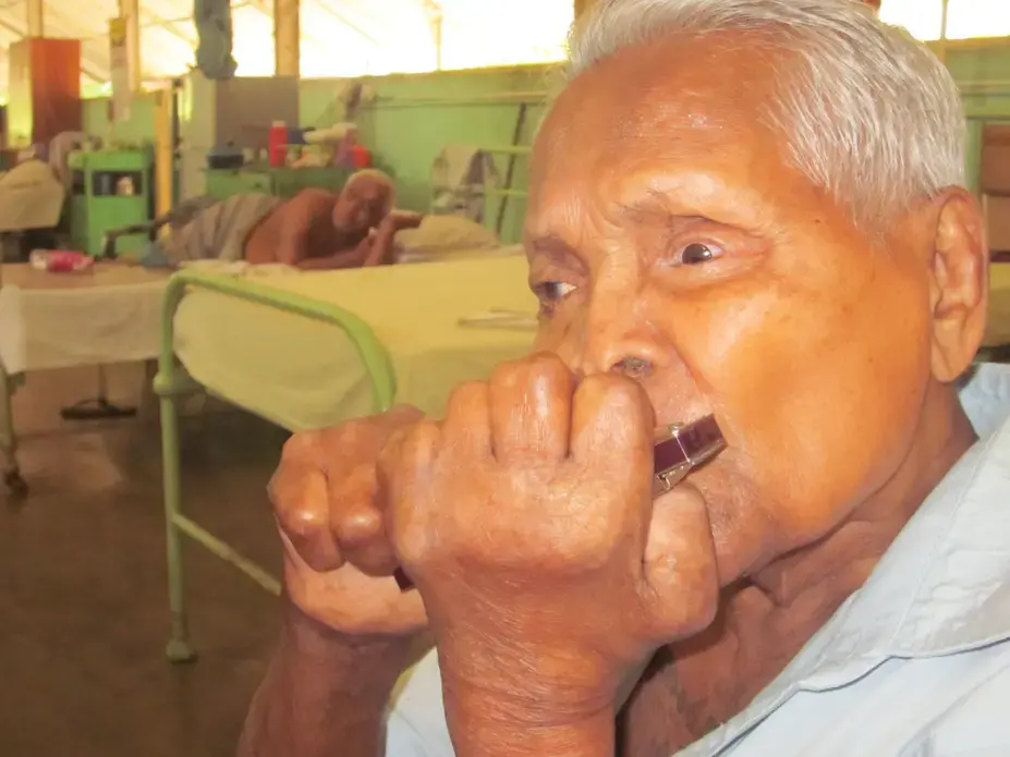 Gunathilike was sent to the Hendala Leprosy Hospital in 1946. He plays the mouth organ in the hospital band. Image by Ross Velton. Sri Lanka, 2015.