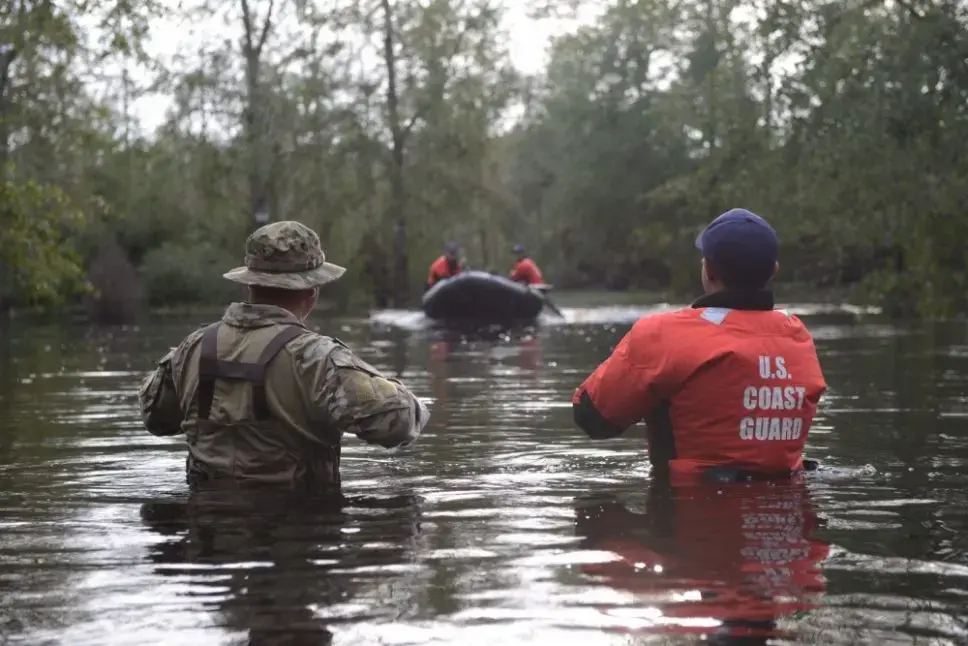 Members of Coast Guard Maritime Safety and Security Team Miami and Coast Guard Tactical Law Enforcement Team South wait to be picked up by their rescue team after completing Hurricane Florence search and rescue operations in Brunswick County Sept. 16, 2018. Image by Petty Officer 3rd Class Trevor Lilburn. United States, 2018.