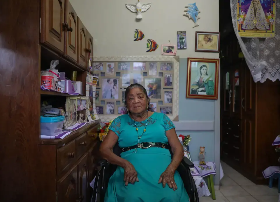 To keep leprosy from continuing to spread throughout her body Maria da Silva Trindade, 94, had the majority of her fingers amputated. Now completely cured of the disease, Trindade has been attending school. Art is her favorite class. Image by Anton L. Delgado. Brazil, 2020.