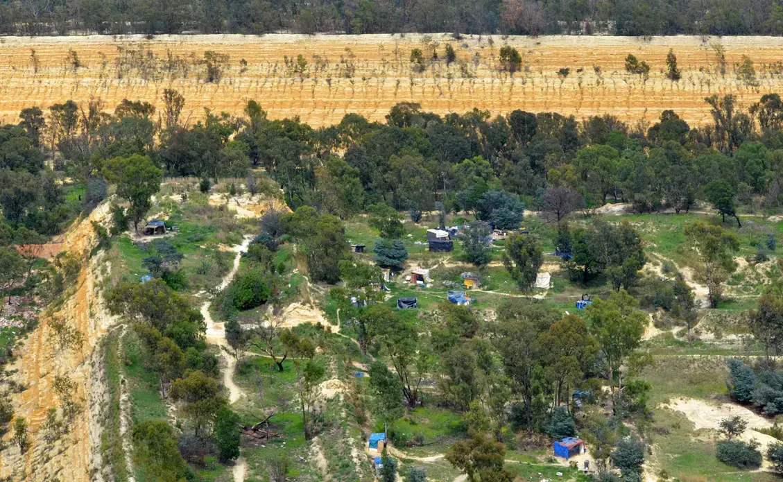An informal settlement near Johannesburg sits atop a pile of unrehabilitated gold mine waste. Image by Mark Olalde. South Africa, 2017.