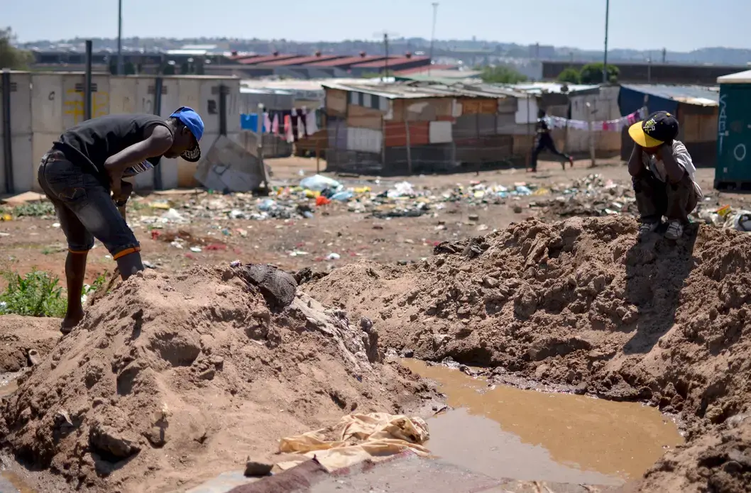 A small-scale miner processes gold ore by hand in an informal settlement in Johannesburg. Image by Mark Olalde. South Africa, 2017.
