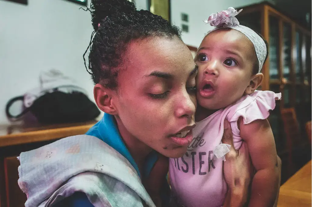 Betania hugging her daughter on a visitor day at a Caracas detention center. She received humanitarian aid that enabled her to breastfeed her child once a day. Image by Ana María Arévalo. Venezuela, 2017.