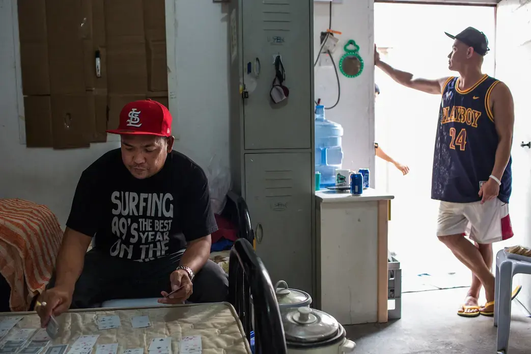 Romeo plays cards to make time pass. He and other workers are not paid by the company since January 2017. They stay in the camp waiting for their case to be processed. Image by Hans Lucas. Qatar, 2017.