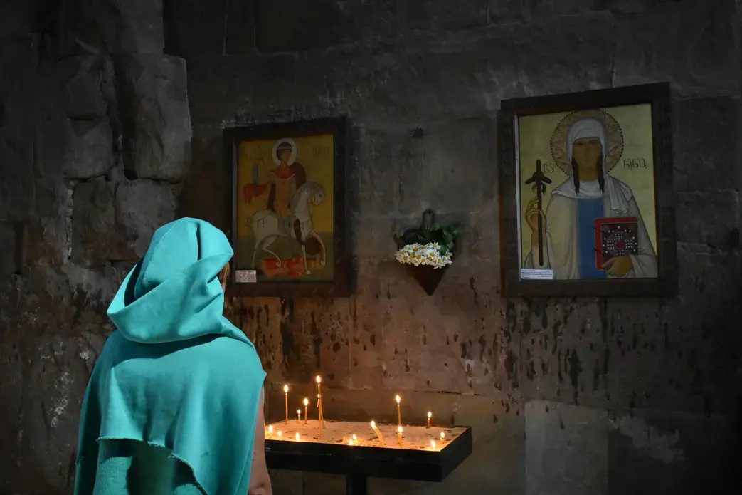 An Orthodox woman prays at the Jvari Monastery. Image by Kaitlyn Johnson. Georgia, 2019.