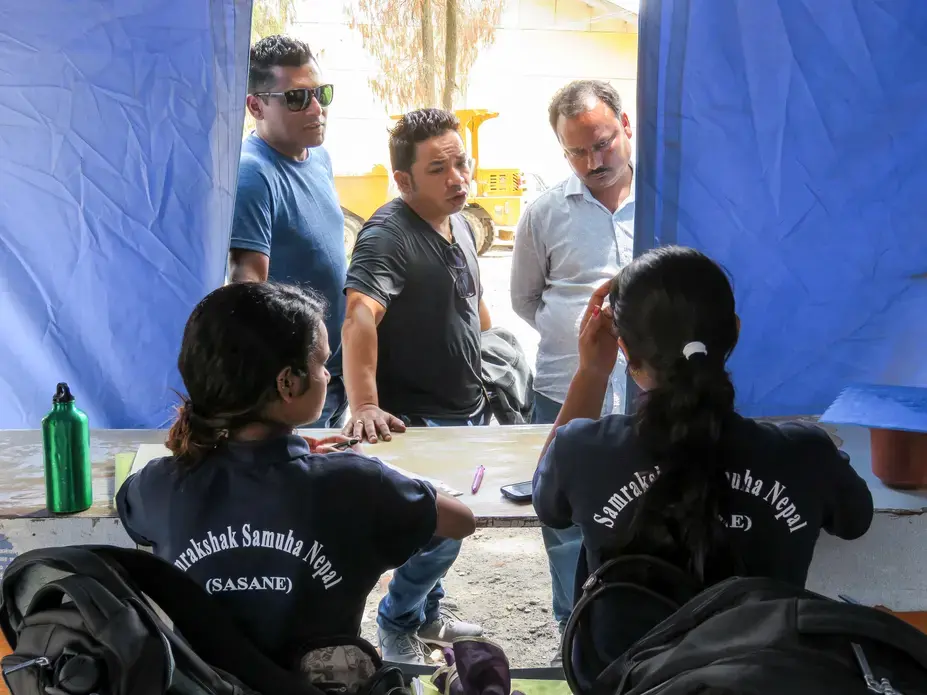 At a Kathmandu police station, trained paralegals Sita and Radhika listen to the stories of three men and file their criminal complaints. Image by Nicole Brigstock. Nepal, 2018.