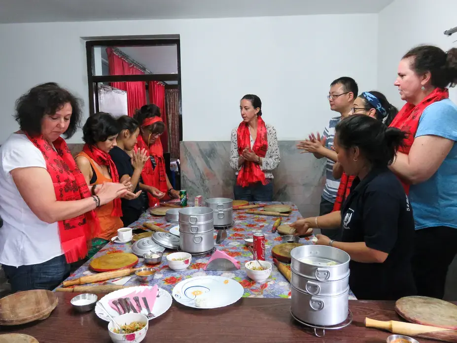 'Fold and pinch, fold and pinch,' repeats Samrakshak Samuha Nepal (SASANE) worker Shanti Guroong. As part of the Sisterhood of Survivors program, trafficking survivors teach visitors to make momos, the Nepali staple dish, while gaining skills in speaking English and in hospitality. Image by Nicole Brigstock. Nepal, 2018.