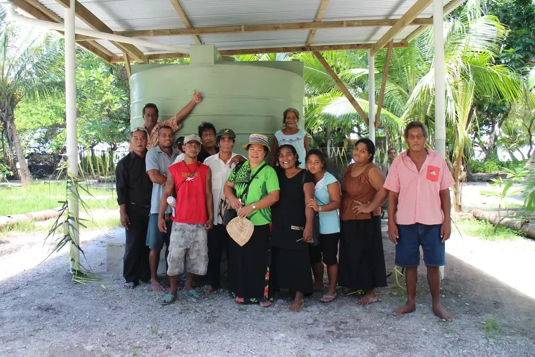 Buariki Village leaders and Professor Pelenise Alofa (center), in front of a newly completed rainwater tank. Image by Janice Cantieri. Kiribati, 2014.