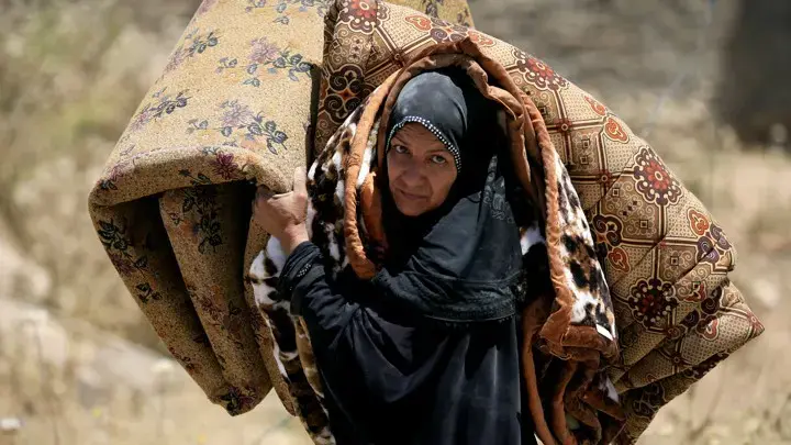 An Iraqi woman fleeing her home in Mosul in 2017. Image by Alaa Al-Marjani with Reuters. Iraq, 2017.