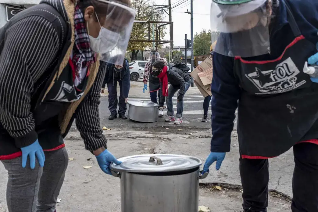 Women from Frente de Organizaciones en Lucha’s “Berta Cáceres” soup kitchen carry their pots for a public soup kitchen in Villa 1-11-14, Buenos Aires, Argentina. Image by Anita Pouchard Serra. Argentina, 2020.