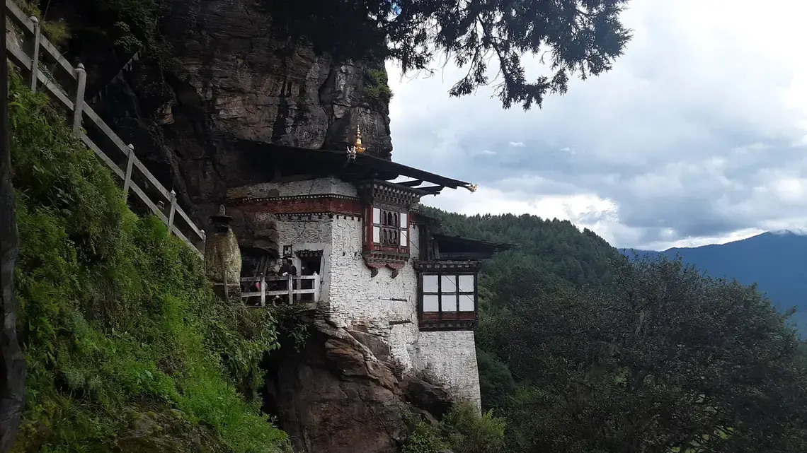 A Buddhist temple hangs off a cliff in the Tang Valley in Bumthang, a district in central Bhutan. Image by Emma Johnson. Bhutan, 2019.