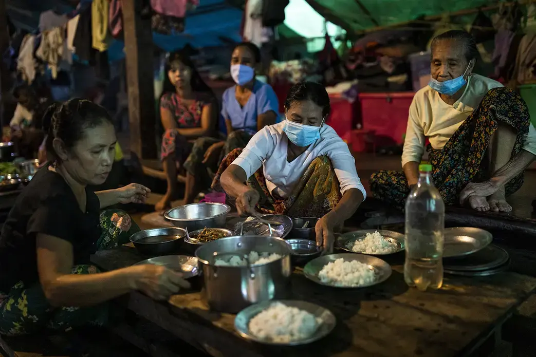 People prepare dinner at the Shitthaung camp for displaced people in Mrauk U, Myanmar, on Aug. 20. International humanitarian access to the township has been largely blocked since early 2019, and many camps are run by local civil society organizations and community volunteers. Image by Hkun Lat/Foreign Policy. Myanmar, 2020.