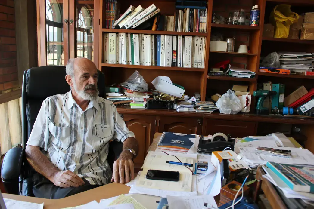 The Rev. Francesco Bortignon in his office explains the daily functions of Mision Scalabrini Cucuta. They provide housing, meals, and education to migrant families.&nbsp;Image by Mariana Rivas. Colombia, 2019.