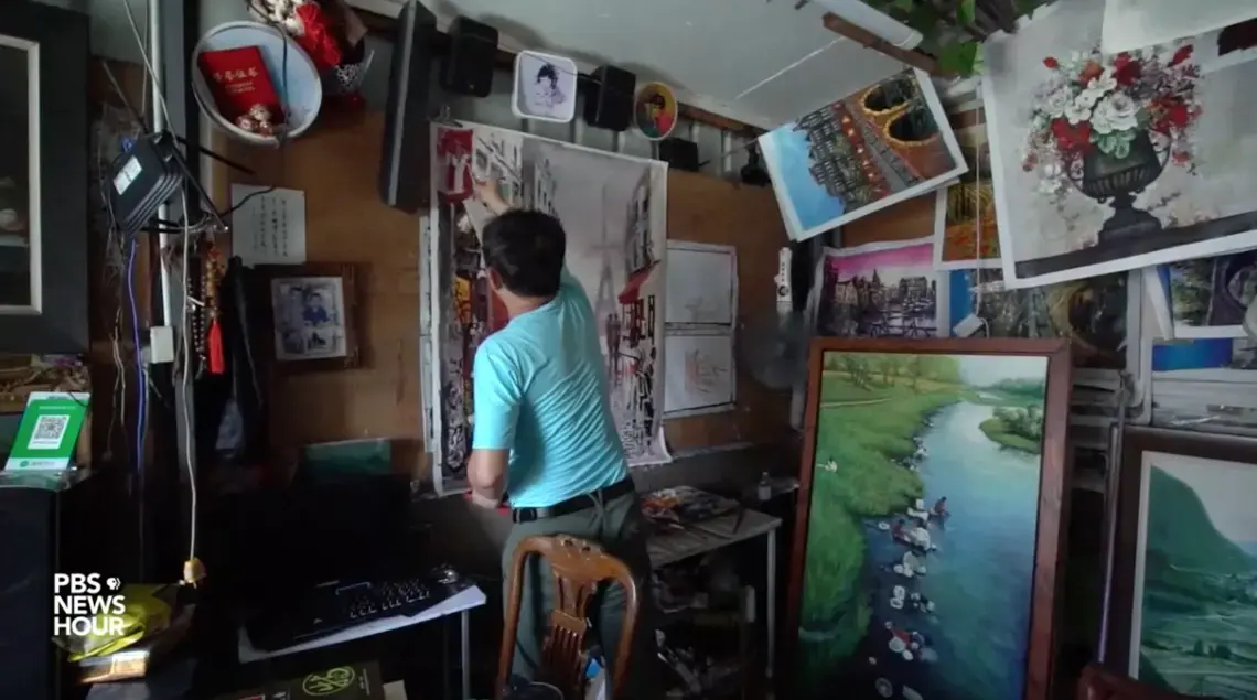 Artist Zeng Muquan has never set foot outside China, but he's painted tens of thousands of European scenes from his studio in the country's southern Guangdong province. Image by PBS NewsHour. China, 2019.