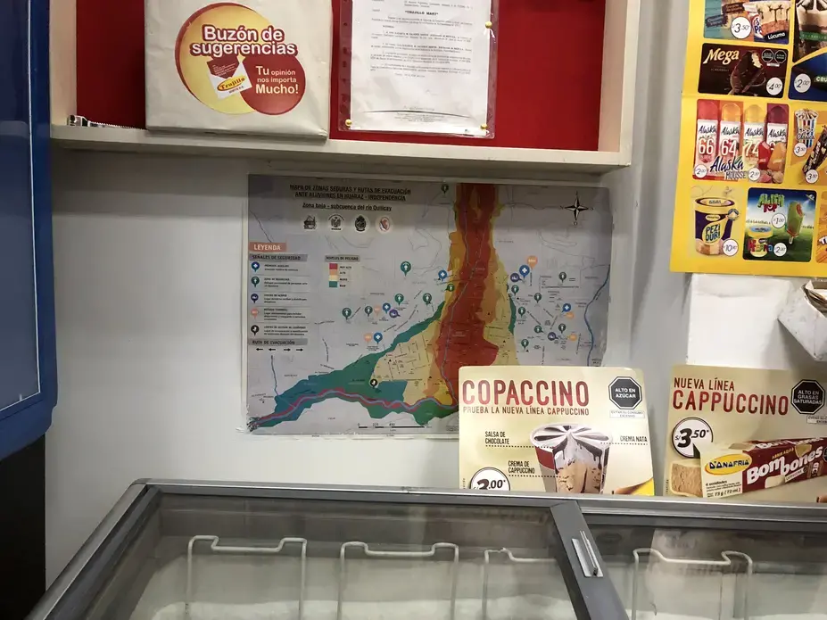 A printed evacuation plan posted behind a freezer in a Huaraz grocery store. Image by&nbsp;Audrey Fromson. Peru, 2019.