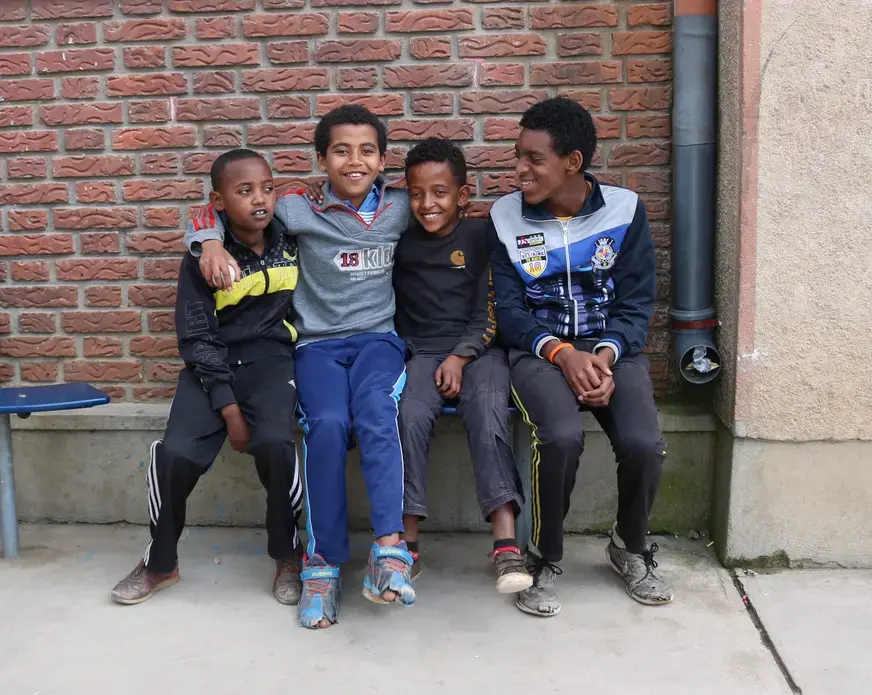 Four boys pose for a photo at Kidana Mehert Children’s Home in Addis Ababa. These boys were playing soccer together with a small ball they found. They live in the home and will continue to live there until they are 18. After they finish school they will decide to work or go to college. This children’s home allows local adoption so anyone of the kids who currently living there can be adopted. Image by Abigail Bekele. Ethiopia, 2018.