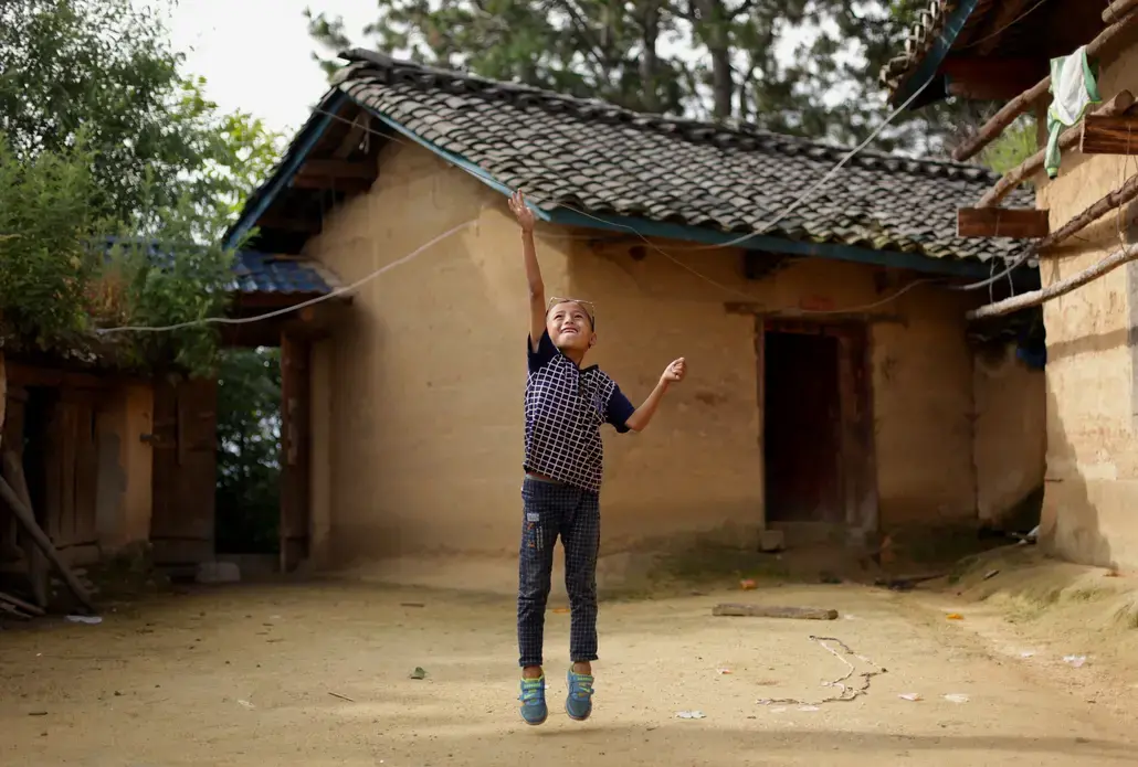 Eight-year-old Wang Jie plays in the courtyard of his family's farmhouse in Liangshan prefecture, Sichuan province. Image by Max Duncan. China, 2016.  