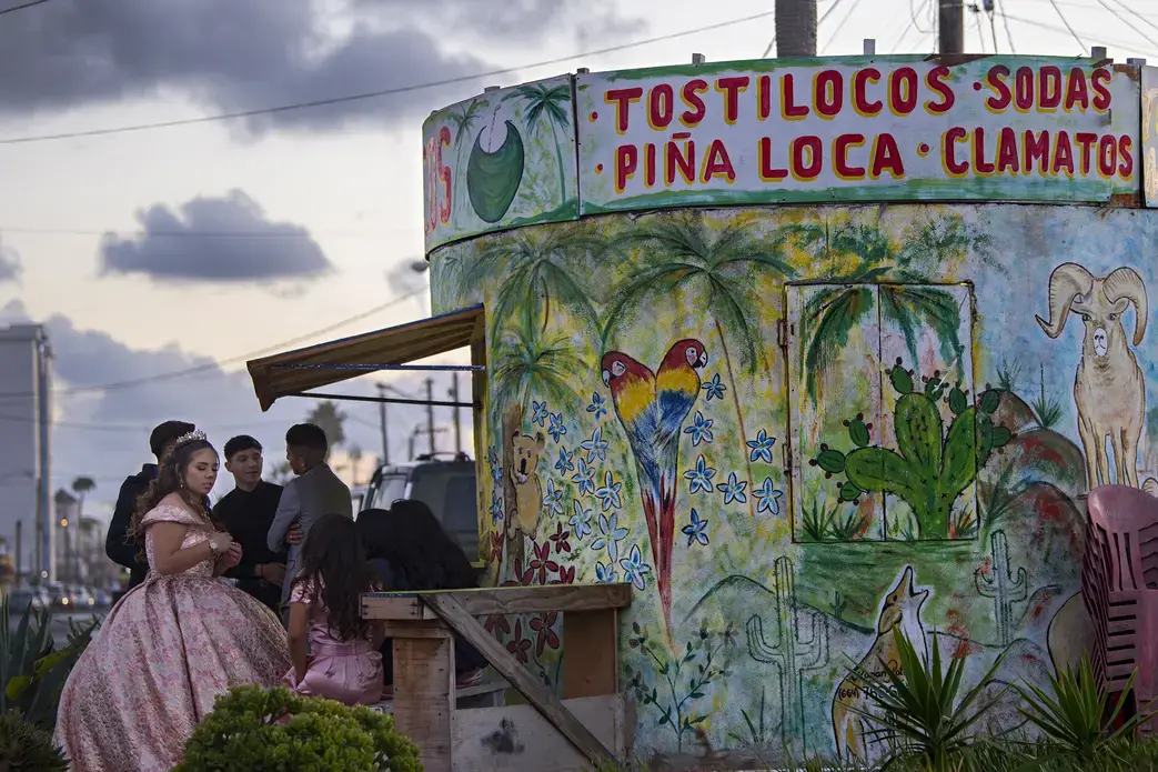 A young woman gathers with friends at Playas de Tijuana for a quinceanera celebration Nov. 29. Quinceanera is the celebration of a girl's 15th birthday, marking the passage from girlhood to womanhood. Image by Amanda Cowan. Mexico, 2019.
