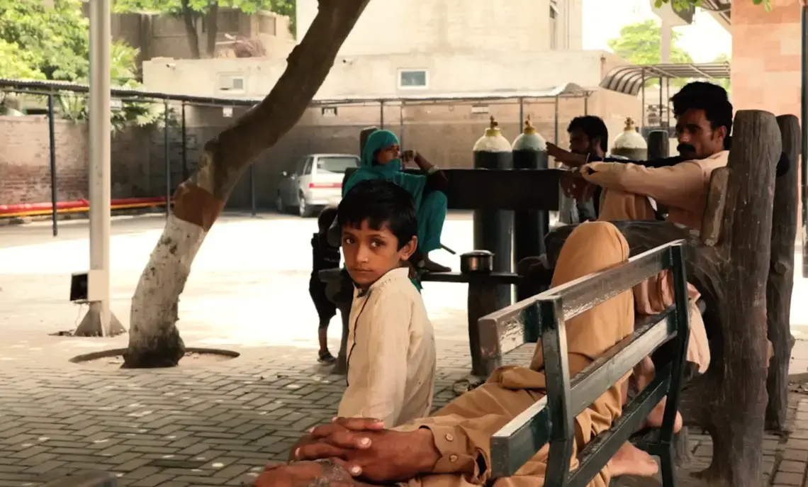 A child sits outside an Ahmadi-funded hospital that provides free healthcare to patients. Image by Isabella Palma Lopez. Pakistan, 2018.
