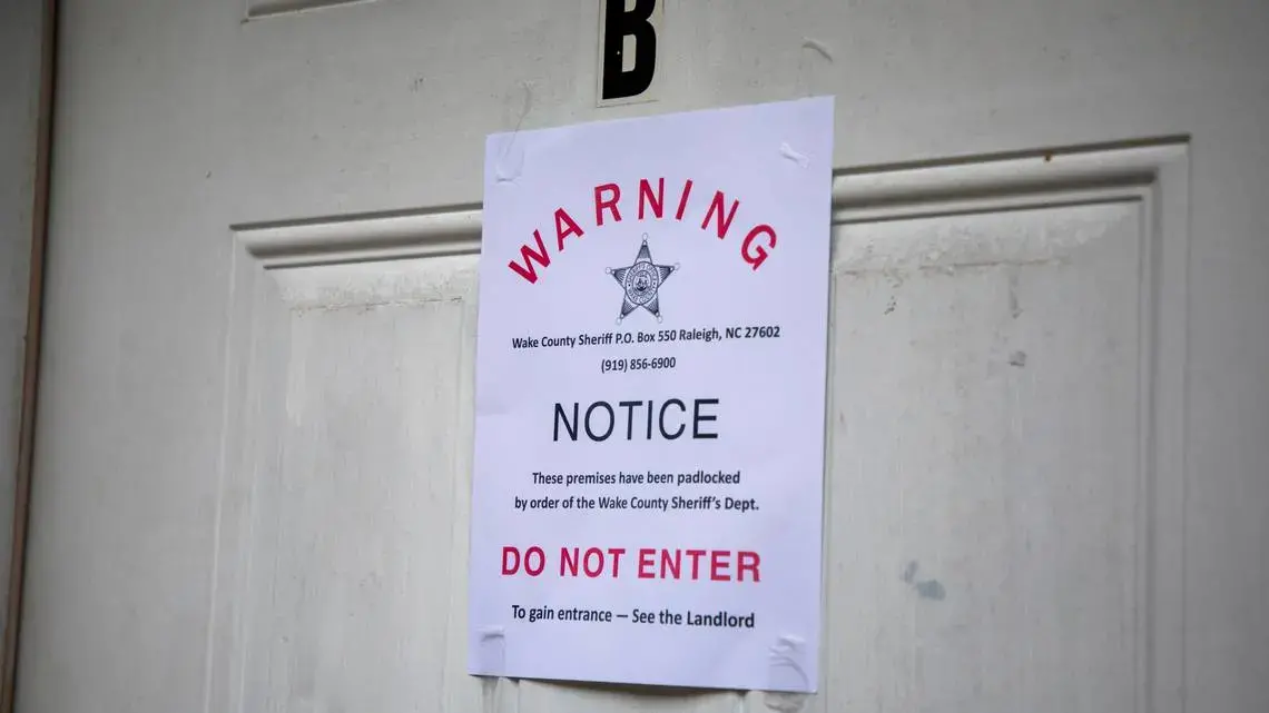 A padlock notice is taped to the door of an apartment, whose tenant was unavailable for comment, in late August in Raleigh, N.C. Image by Casey Toth. United States, 2020.