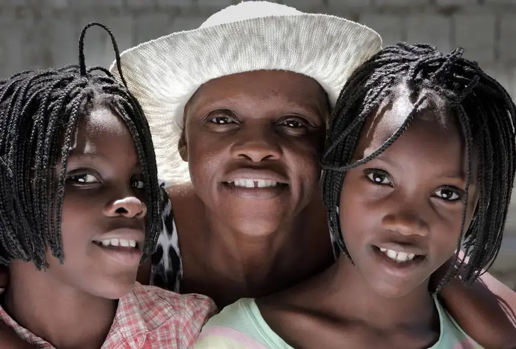 Guerda Janvier (center), who has advanced cervical cancer, wants more than anything to see her 11-year-old twin daughters, Brithney (left) and Briana Osselin (right), grow up.
Image by José A. Iglesias. Haiti, 2018.